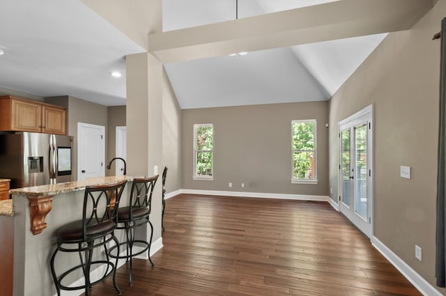 990 Iron Hill Rd, Burns, TN 37029 - kitchen featuring stainless steel refrigerator with ice dispenser, light stone counters, baseboards, a kitchen breakfast bar, and dark wood finished floors