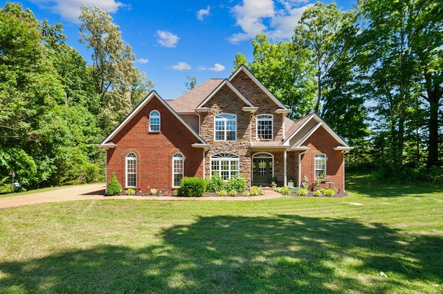 990 Iron Hill Rd, Burns, TN 37029 - traditional-style house featuring stone siding, a front yard, and brick siding