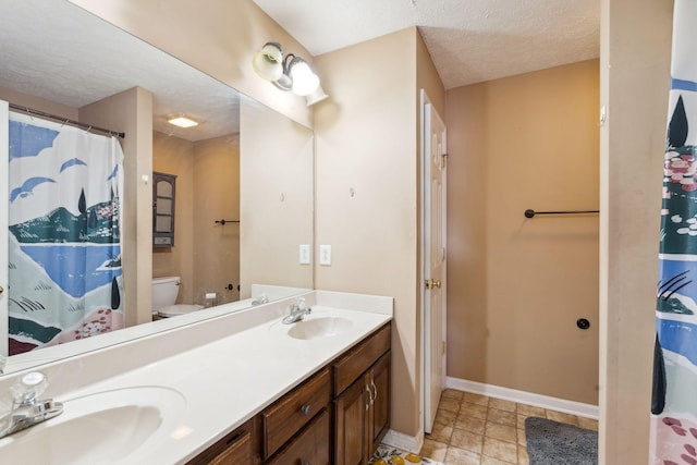 5512 Oak Chase Dr, Antioch, TN 37013 - full bathroom featuring baseboards, double vanity, a textured ceiling, and a sink
