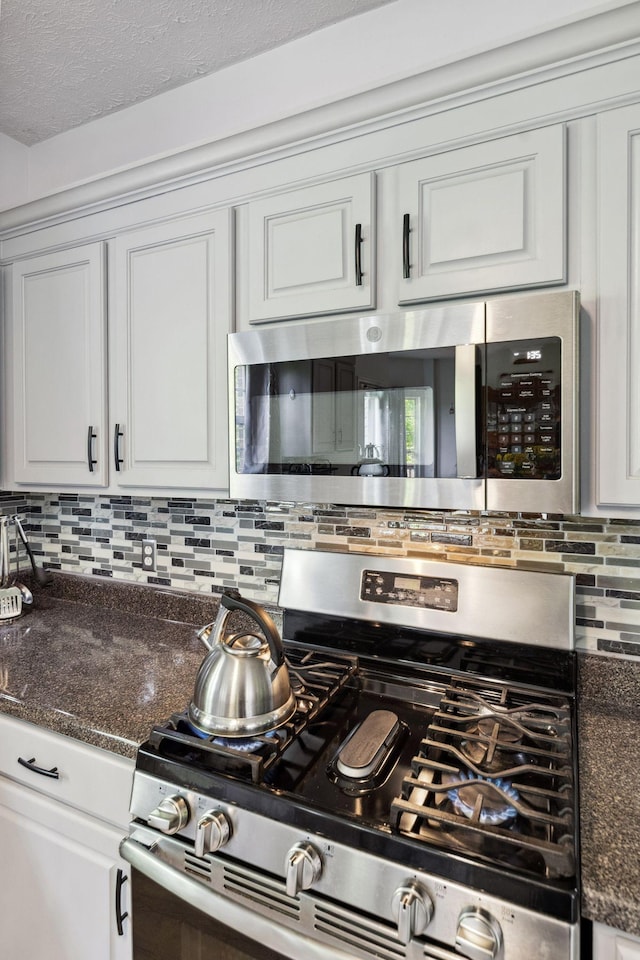 5512 Oak Chase Dr, Antioch, TN 37013 - kitchen featuring white cabinets, stainless steel appliances, decorative backsplash, and dark stone counters