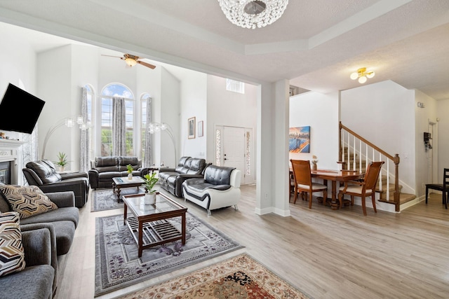 5512 Oak Chase Dr, Antioch, TN 37013 - living area featuring a towering ceiling, baseboards, a glass covered fireplace, stairs, and light wood-style flooring