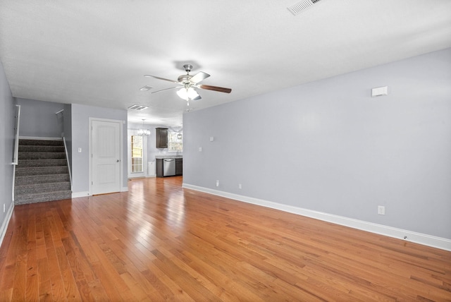 1145 Racker Dr, Clarksville, TN 37043 - unfurnished living room featuring visible vents, baseboards, stairway, light wood-type flooring, and a ceiling fan