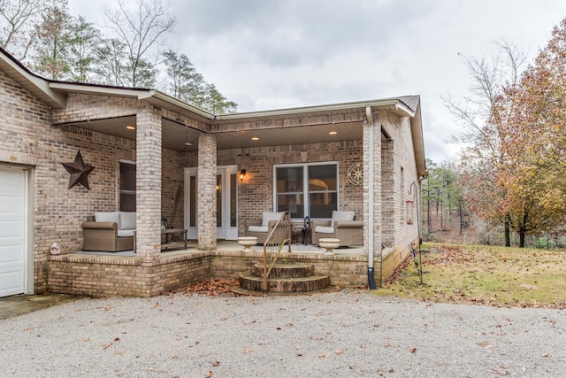 back of house with a porch and brick siding