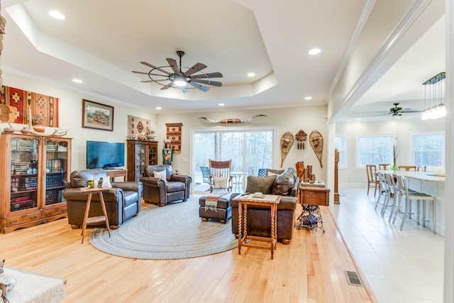 living room featuring ceiling fan, visible vents, wood-type flooring, a tray ceiling, and recessed lighting