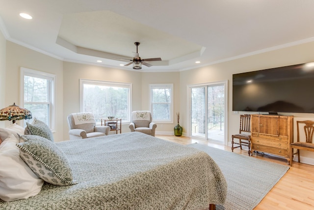 bedroom with access to outside, light wood finished floors, a raised ceiling, recessed lighting, and ornamental molding