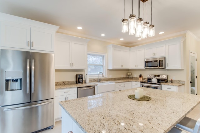 kitchen with white cabinets, a breakfast bar, a sink, stainless steel appliances, and a kitchen island