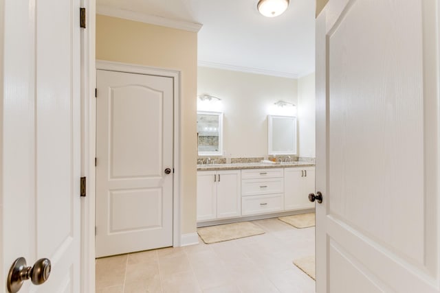 bathroom featuring crown molding, tile patterned floors, double vanity, and a sink