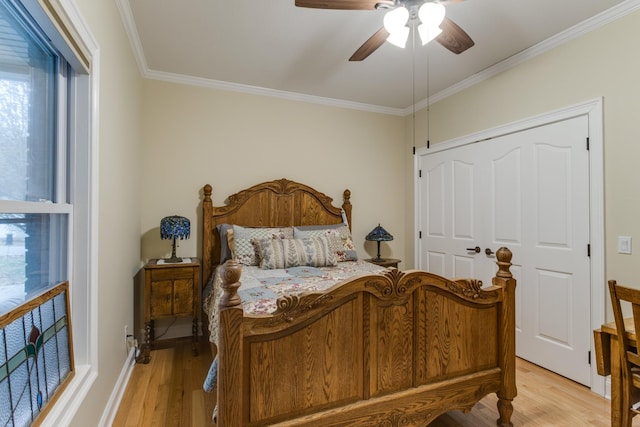 bedroom with crown molding, light wood-style flooring, and ceiling fan
