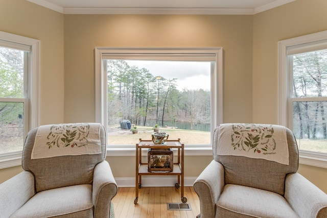 living area featuring visible vents, a wealth of natural light, and hardwood / wood-style flooring