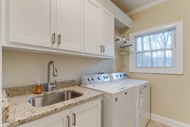 laundry area featuring cabinet space, crown molding, a sink, separate washer and dryer, and light tile patterned floors