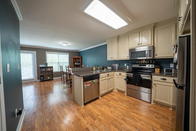 215 Desperado Ave, Pulaski, TN 38478 - kitchen featuring dark countertops, stainless steel appliances, a peninsula, and cream cabinetry