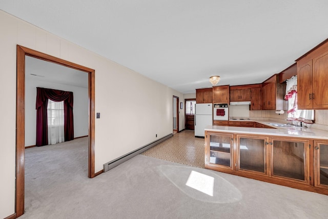 kitchen with baseboard heating, a sink, white appliances, light countertops, and under cabinet range hood