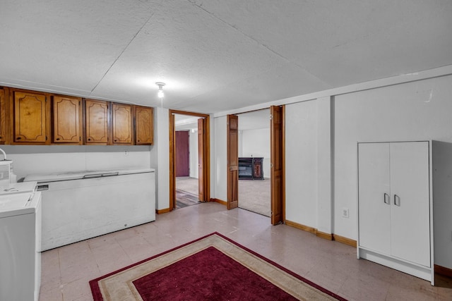 interior space with baseboards, a textured ceiling, cabinet space, and washer and dryer