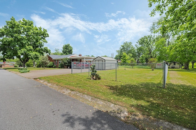 view of front of house featuring a detached carport, fence, a front yard, and aphalt driveway