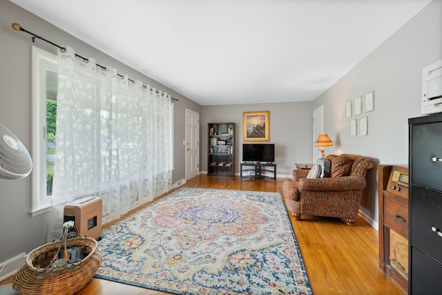 living area featuring light wood-style floors, baseboards, and visible vents