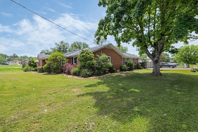 view of side of home featuring a yard and brick siding