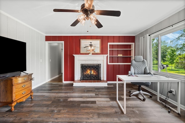 office with crown molding, ceiling fan, a brick fireplace, and wood finished floors