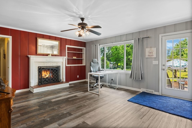 interior space featuring crown molding, ceiling fan, and a decorative wall