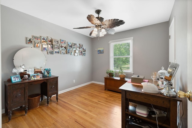office area featuring light wood-type flooring, a ceiling fan, and baseboards