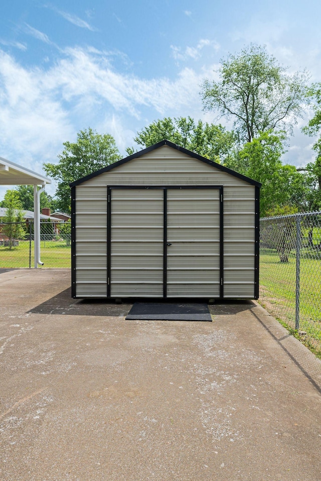 view of outbuilding with fence and an outbuilding