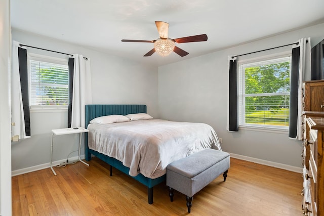 bedroom featuring a ceiling fan, baseboards, and light wood-type flooring