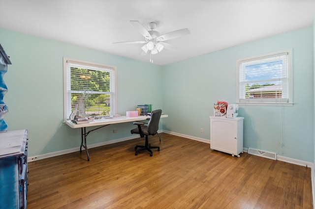 home office with visible vents, baseboards, ceiling fan, and wood finished floors