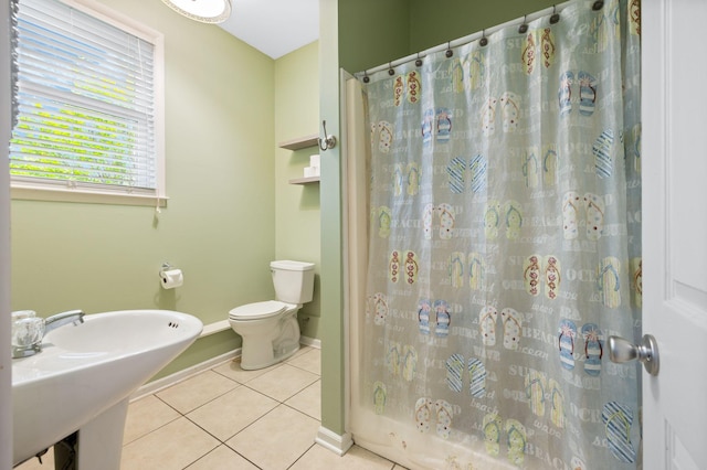 full bath featuring curtained shower, a sink, tile patterned floors, baseboards, and toilet