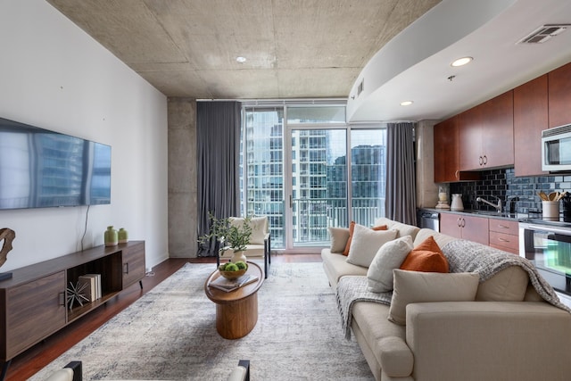 living area with visible vents, dark wood-style flooring, baseboards, recessed lighting, and floor to ceiling windows