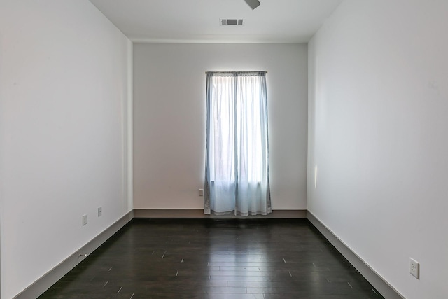 spare room featuring visible vents and dark wood-style floors