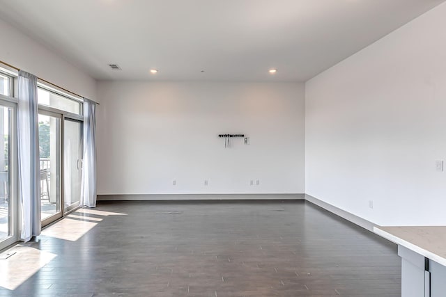 spare room featuring recessed lighting, baseboards, dark wood finished floors, and visible vents