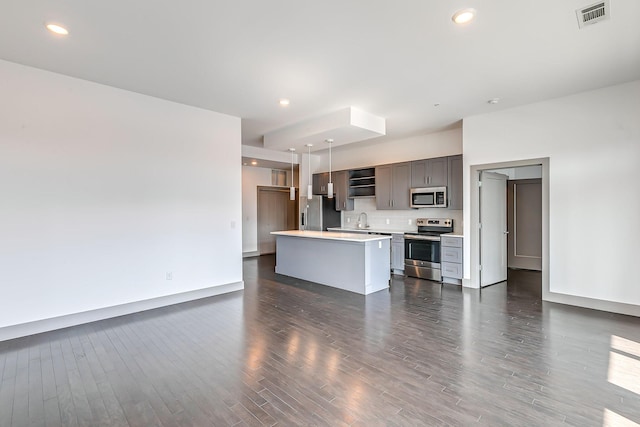 unfurnished living room with a sink, recessed lighting, dark wood-style flooring, and visible vents