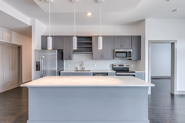 kitchen with a sink, appliances with stainless steel finishes, decorative backsplash, and dark wood-type flooring