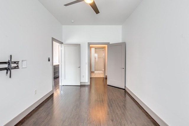 unfurnished bedroom featuring baseboards, a ceiling fan, and dark wood-style flooring