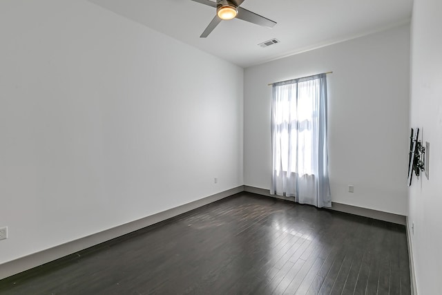 spare room with a ceiling fan, dark wood-type flooring, and visible vents