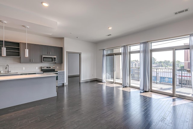 kitchen with a sink, light countertops, stainless steel appliances, backsplash, and visible vents