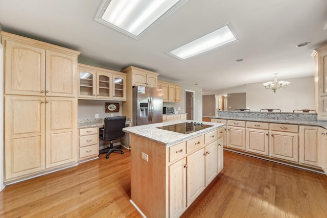 447 Canaan Rd, Columbia, TN 38401 - kitchen featuring stainless steel fridge, built in desk, light brown cabinets, black electric cooktop, and a center island