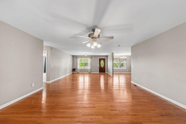 447 Canaan Rd, Columbia, TN 38401 - unfurnished living room with baseboards, ceiling fan with notable chandelier, and light wood-style flooring