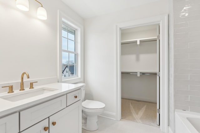 full bath featuring vanity, bathing tub / shower combination, toilet, a walk in closet, and tile patterned floors
