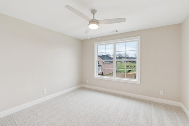 empty room with a ceiling fan, baseboards, visible vents, and light carpet