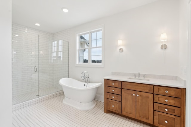 bathroom with baseboards, a shower stall, a soaking tub, and vanity