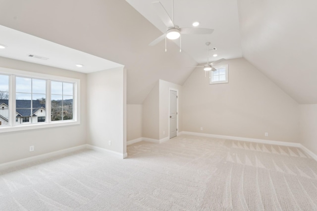 bonus room featuring visible vents, light carpet, baseboards, ceiling fan, and vaulted ceiling
