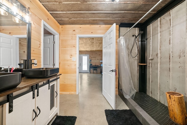 4231 Lylewood Rd, Indian Mound, TN 37079 - bathroom featuring finished concrete floors, a stall shower, wooden walls, and vanity