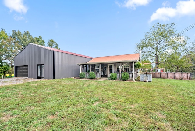 4231 Lylewood Rd, Indian Mound, TN 37079 - back of house with an outdoor structure, a garage, fence, a lawn, and a porch