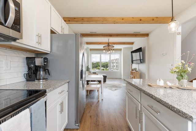 301 Harper Lndg Unit 301, Chapel Hill, TN 37034 - kitchen featuring appliances with stainless steel finishes, tasteful backsplash, wood finished floors, white cabinets, and pendant lighting