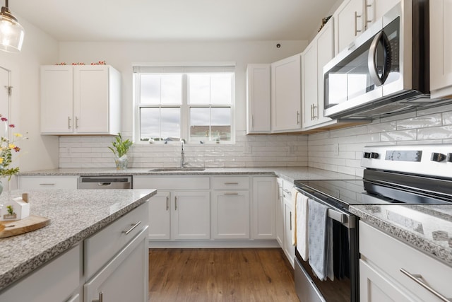 301 Harper Lndg Unit 301, Chapel Hill, TN 37034 - kitchen with appliances with stainless steel finishes, white cabinets, light wood finished floors, and tasteful backsplash