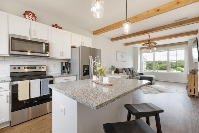 301 Harper Lndg Unit 301, Chapel Hill, TN 37034 - kitchen with appliances with stainless steel finishes, light wood-style floors, open floor plan, tasteful backsplash, and white cabinetry
