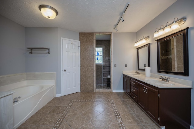 bathroom with baseboards, a sink, and a textured ceiling