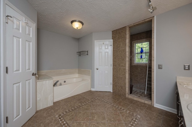 full bath featuring a garden tub, vanity, a walk in shower, baseboards, and tile patterned floors