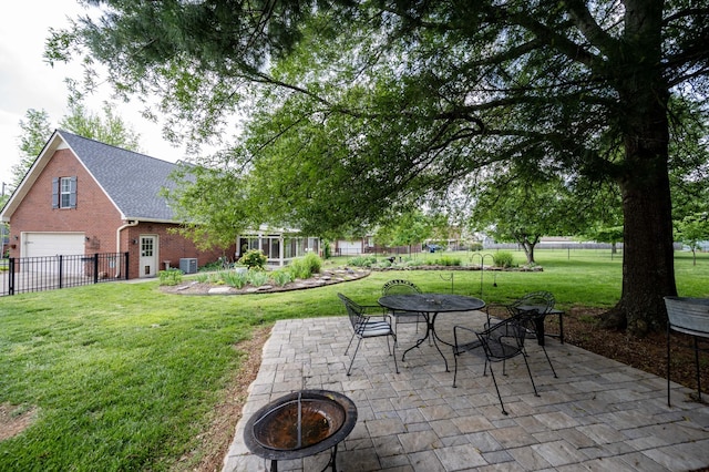 view of patio / terrace with central air condition unit, an outdoor fire pit, fence, and a garage