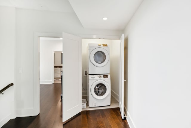 clothes washing area featuring laundry area, recessed lighting, baseboards, stacked washer / dryer, and dark wood-style floors